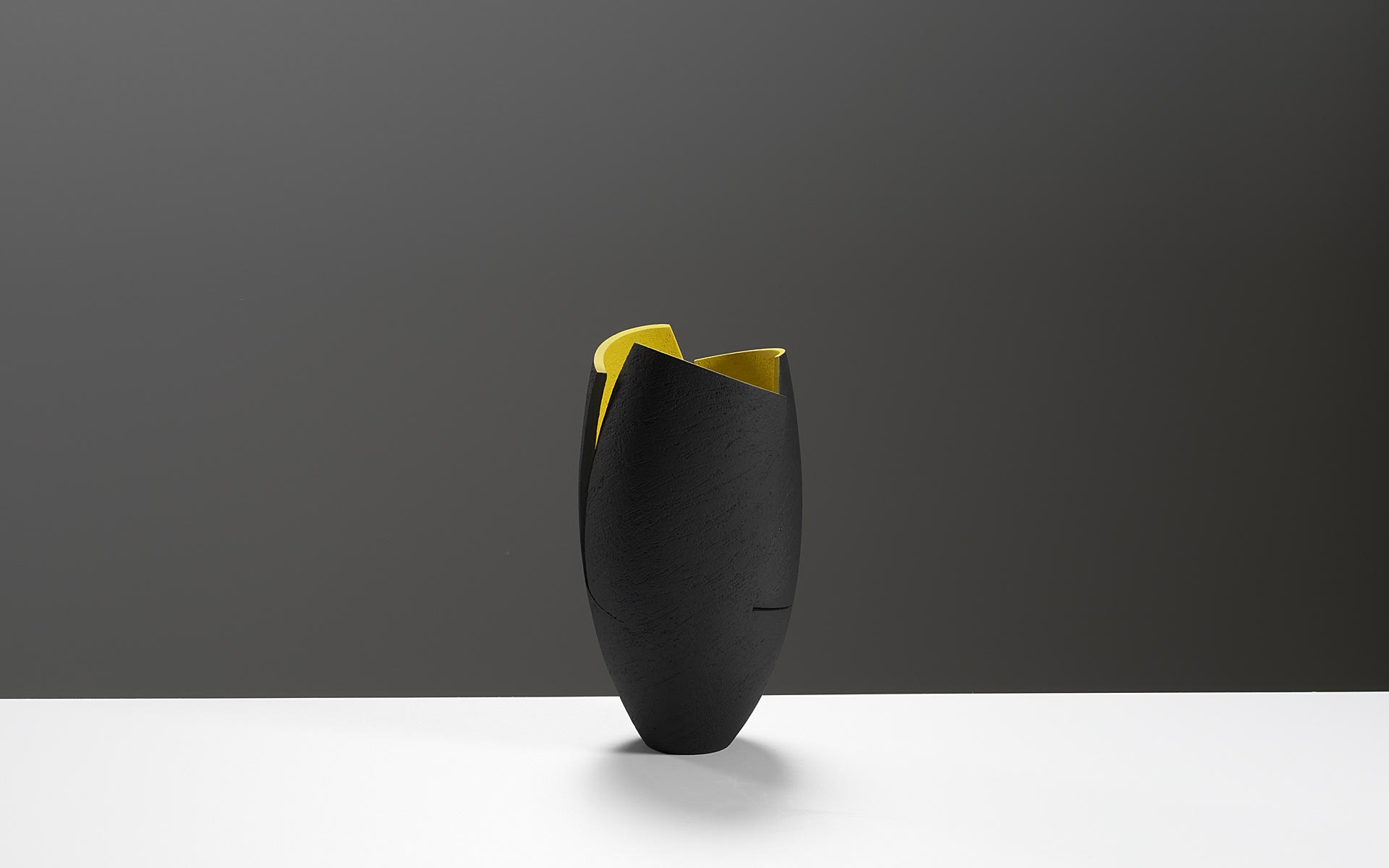 Black cut and altered vessel with yellow interior